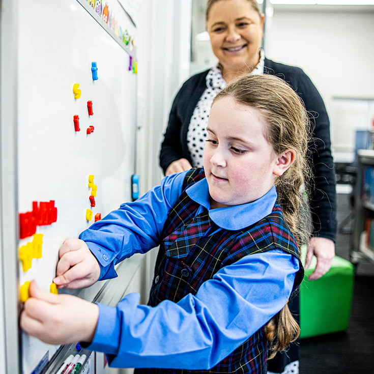 Teacher helping student at Our Lady of Lourdes Seven Hills